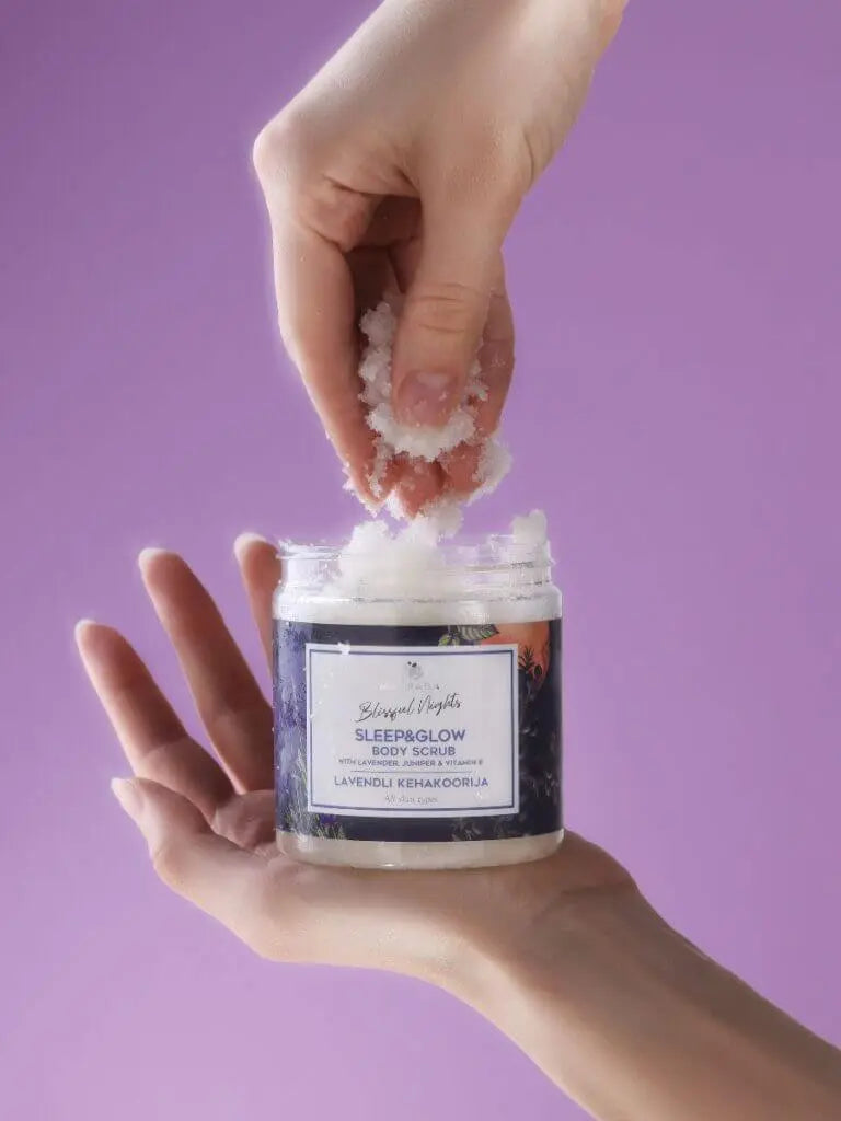 Hands holding a jar of Sleep&Glow Body Scrub with lavender and sea salt for organic skincare.